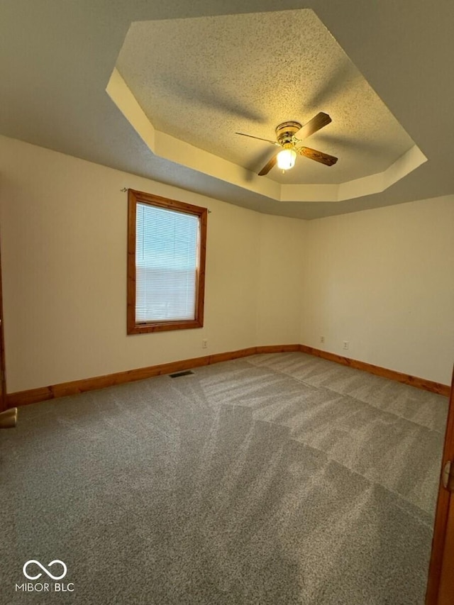 1421 S Meridian St, Indianapolis, IN 46225 - empty room featuring a tray ceiling, a ceiling fan, baseboards, a textured ceiling, and carpet flooring