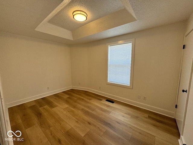 1421 S Meridian St, Indianapolis, IN 46225 - unfurnished room featuring a raised ceiling, a textured ceiling, wood finished floors, and baseboards