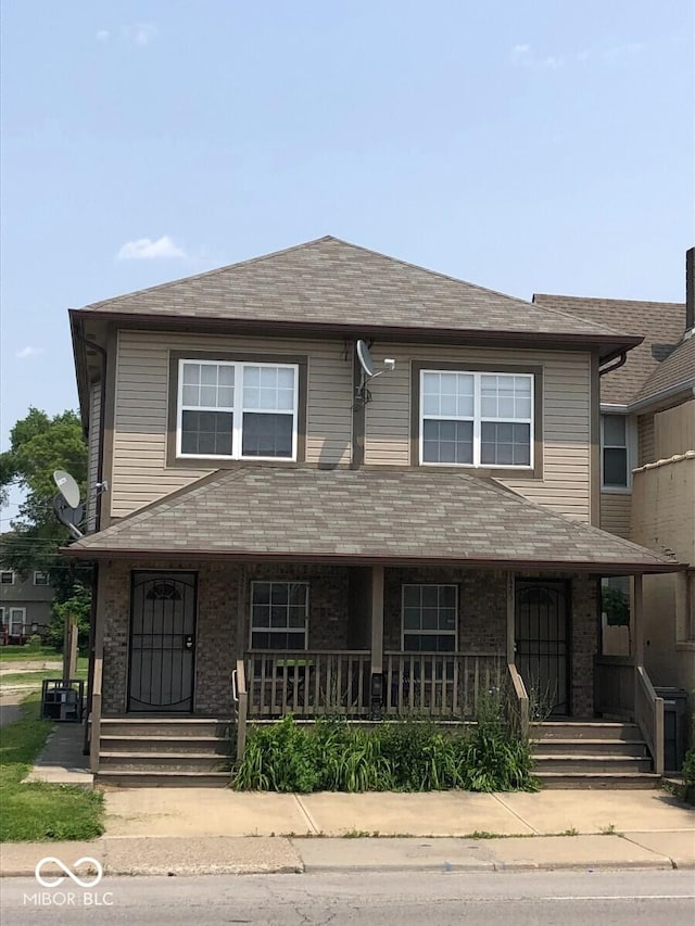 1421 S Meridian St, Indianapolis, IN 46225 - view of property with a porch, brick siding, and a shingled roof