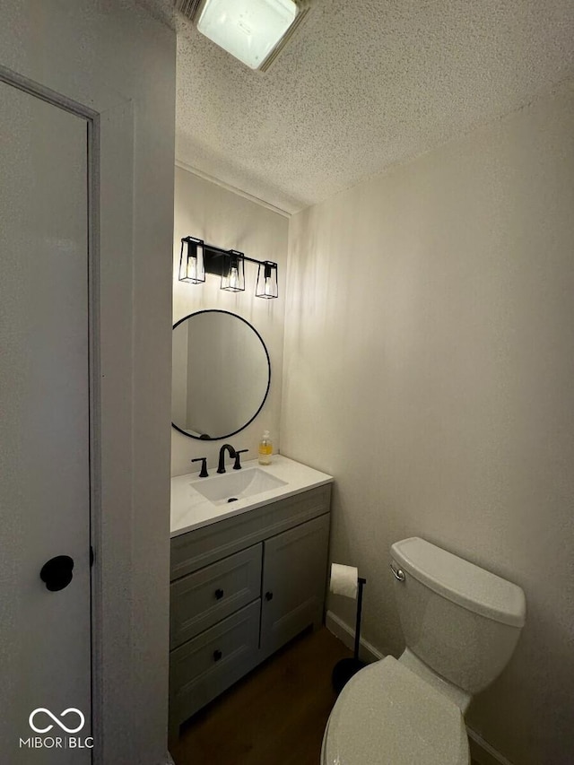 1421 S Meridian St, Indianapolis, IN 46225 - bathroom with vanity, toilet, a textured ceiling, and wood finished floors