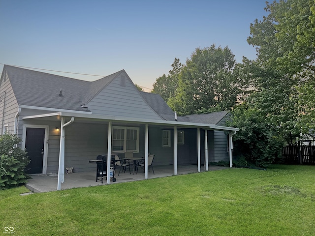 1141 N Shadeland Ave, Indianapolis, IN 46219 - back of property at dusk featuring a patio and a shingled roof