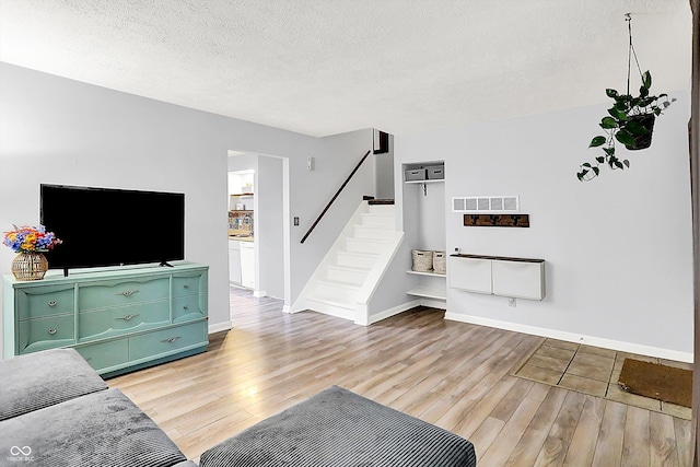 7504 Troon Ct, Indianapolis, IN 46237 - living area featuring light wood-style floors, baseboards, stairs, and a textured ceiling