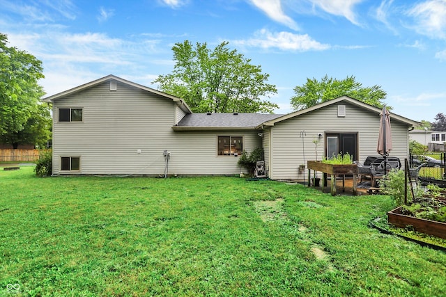 7504 Troon Ct, Indianapolis, IN 46237 - back of property with a lawn, a vegetable garden, and roof with shingles