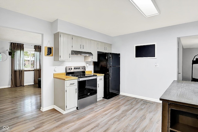 7504 Troon Ct, Indianapolis, IN 46237 - kitchen featuring stainless steel range with electric cooktop, freestanding refrigerator, under cabinet range hood, light wood-style floors, and baseboards