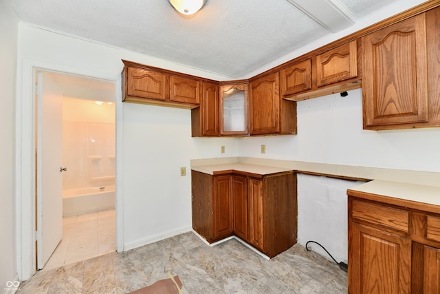 1346 W 27th St, Indianapolis, IN 46208 - kitchen featuring brown cabinets, glass insert cabinets, and light countertops
