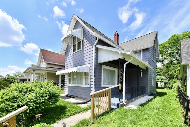 1346 W 27th St, Indianapolis, IN 46208 - view of side of property featuring a chimney, a yard, and roof with shingles