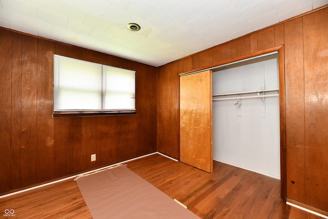 1346 W 27th St, Indianapolis, IN 46208 - unfurnished bedroom featuring wood finished floors, a closet, and wooden walls