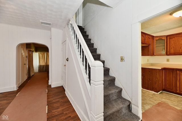 1346 W 27th St, Indianapolis, IN 46208 - stairway with arched walkways, wood finished floors, and a textured ceiling