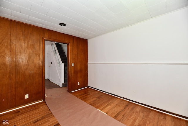 1346 W 27th St, Indianapolis, IN 46208 - empty room featuring wood finished floors, stairs, and wooden walls