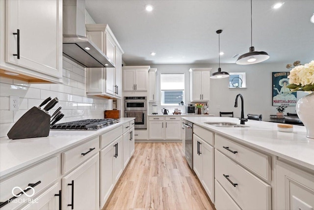 7154 Covington St, Lebanon, IN 46052 - kitchen with wall chimney exhaust hood, a sink, appliances with stainless steel finishes, light wood-style floors, and white cabinets
