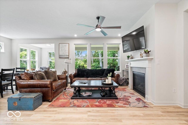 7154 Covington St, Lebanon, IN 46052 - living area with wood finished floors, a ceiling fan, a glass covered fireplace, recessed lighting, and baseboards
