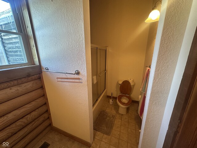 2858 N Stout Rd, Liberty, IN 47353 - full bathroom featuring toilet, a textured wall, and enclosed tub / shower combo