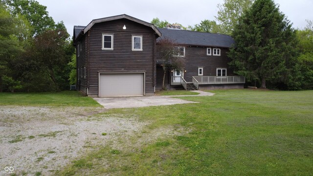 2858 N Stout Rd, Liberty, IN 47353 - view of front facade featuring a front lawn, a wooden deck, driveway, and a garage