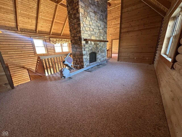 2858 N Stout Rd, Liberty, IN 47353 - unfurnished living room featuring high vaulted ceiling, rustic walls, wood ceiling with exposed beams, carpet, and a fireplace