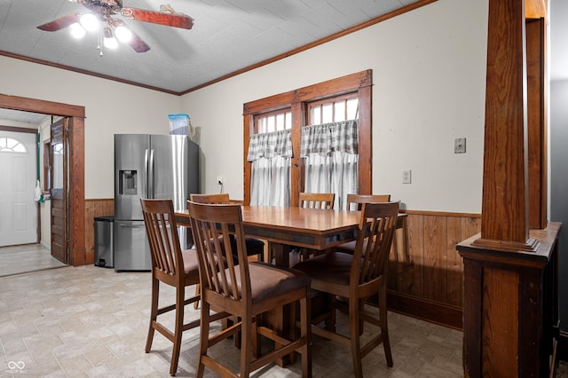 11780 S Hoover St, Clinton, IN 47842 - dining room featuring a wainscoted wall, wood walls, a ceiling fan, ornamental molding, and stone finish flooring