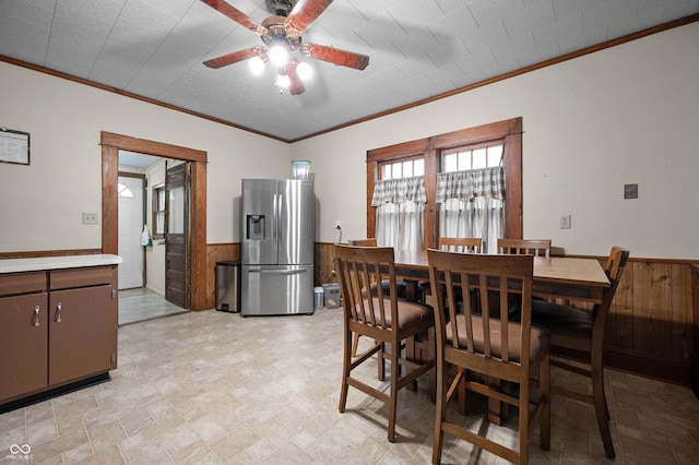 11780 S Hoover St, Clinton, IN 47842 - dining space with ceiling fan, wainscoting, crown molding, wooden walls, and stone finish floors
