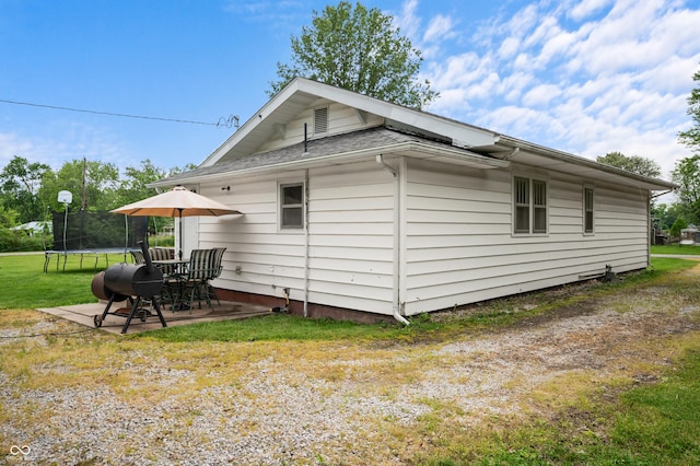 11780 S Hoover St, Clinton, IN 47842 - view of side of home featuring a trampoline, a patio, a lawn, and roof with shingles