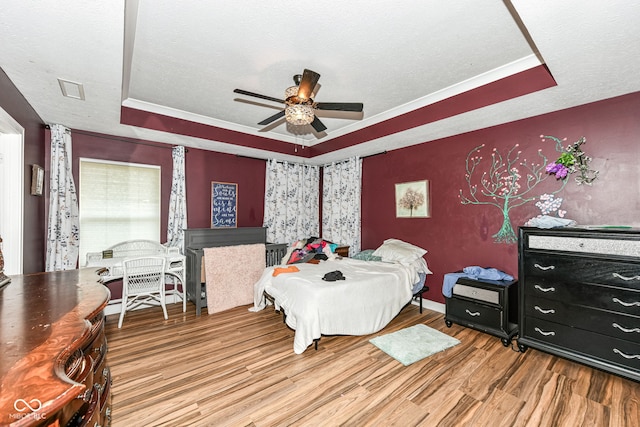 1217 Old Vines Trl, Greenwood, IN 46143 - bedroom featuring a tray ceiling, wood finished floors, a textured ceiling, and ceiling fan