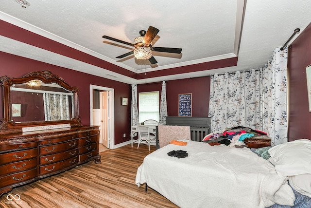 1217 Old Vines Trl, Greenwood, IN 46143 - bedroom featuring a raised ceiling, wood finished floors, a ceiling fan, and a textured ceiling