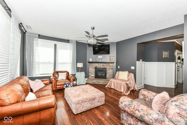 1217 Old Vines Trl, Greenwood, IN 46143 - living area featuring wood finished floors, a ceiling fan, a glass covered fireplace, wainscoting, and a textured ceiling