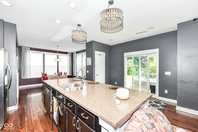 1217 Old Vines Trl, Greenwood, IN 46143 - kitchen with dark wood-style floors, light stone counters, an island with sink, a chandelier, and pendant lighting