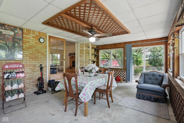 1914 S Avon Ave, Avon, IN 46123 - sunroom / solarium featuring a paneled ceiling, ceiling fan, unfinished concrete flooring, brick wall, and outdoor dining space