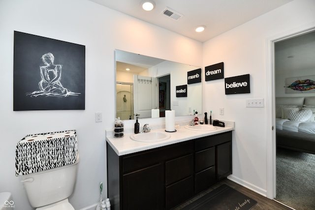 6883 Honeysuckle Way, Pendleton, IN 46064 - full bathroom with double vanity, ensuite bathroom, toilet, wood finished floors, and baseboards