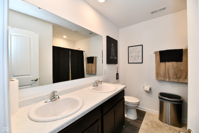 6883 Honeysuckle Way, Pendleton, IN 46064 - bathroom with double vanity, baseboards, toilet, wood finished floors, and recessed lighting