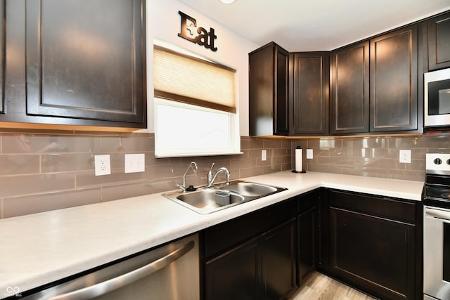 6883 Honeysuckle Way, Pendleton, IN 46064 - kitchen with stainless steel appliances, a sink, tasteful backsplash, light countertops, and dark brown cabinets