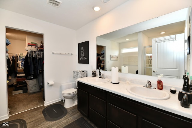 6883 Honeysuckle Way, Pendleton, IN 46064 - bathroom with a walk in closet, double vanity, toilet, a shower with door, and wood finished floors