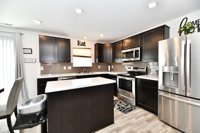 6883 Honeysuckle Way, Pendleton, IN 46064 - kitchen featuring stainless steel appliances, a sink, light countertops, tasteful backsplash, and a kitchen island