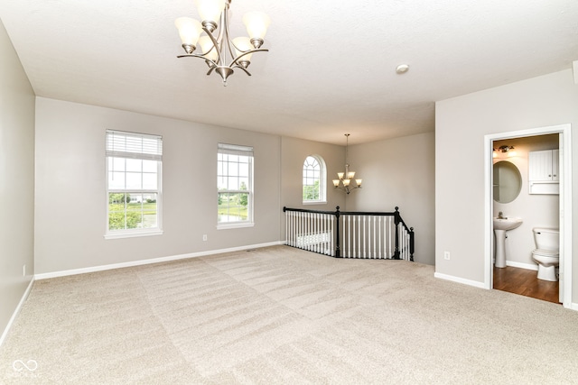 174 Straughn Ln, Westfield, IN 46074 - spare room with a chandelier, carpet flooring, baseboards, and a sink