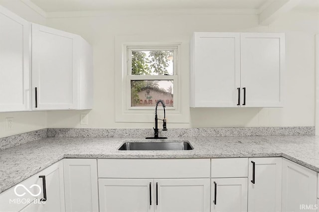 701 E Memorial Dr, Muncie, IN 47302 - kitchen featuring a sink, white cabinets, light stone countertops, and crown molding