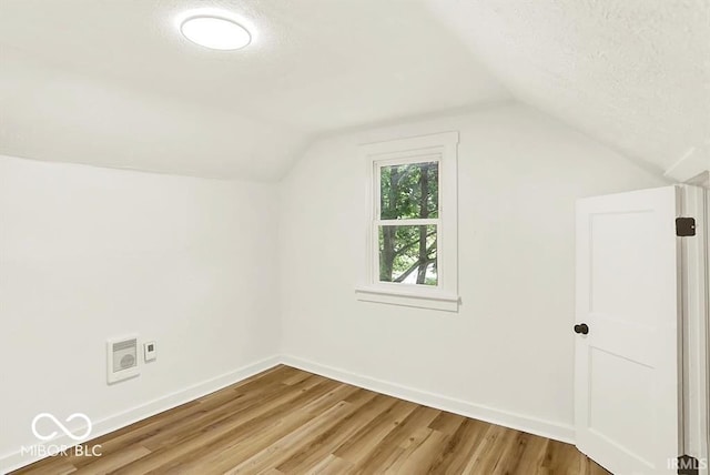 701 E Memorial Dr, Muncie, IN 47302 - bonus room featuring vaulted ceiling, baseboards, light wood finished floors, and a textured ceiling