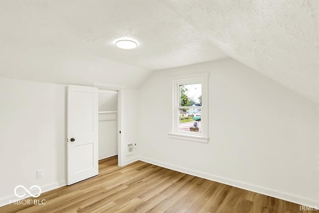 701 E Memorial Dr, Muncie, IN 47302 - bonus room with light wood-style flooring, a textured ceiling, baseboards, and vaulted ceiling