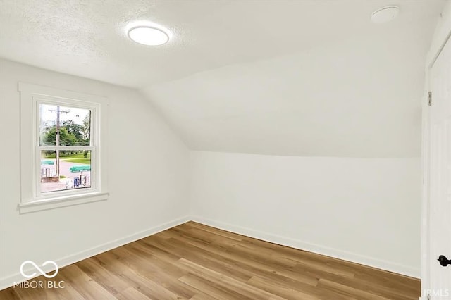 701 E Memorial Dr, Muncie, IN 47302 - bonus room with light wood finished floors, lofted ceiling, baseboards, and a textured ceiling