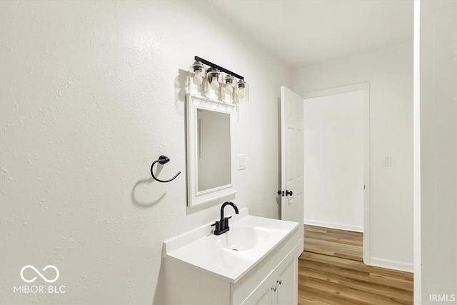 701 E Memorial Dr, Muncie, IN 47302 - bathroom featuring vanity, wood finished floors, and baseboards
