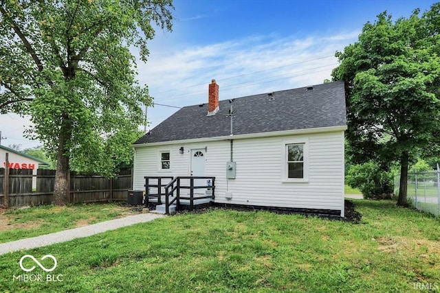 701 E Memorial Dr, Muncie, IN 47302 - rear view of house with a shingled roof, a chimney, and central AC unit