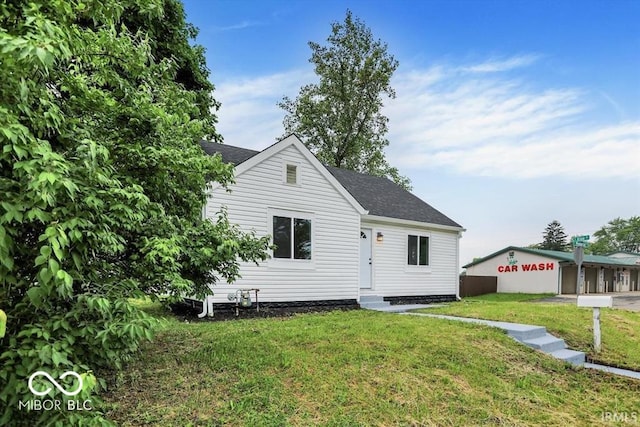 701 E Memorial Dr, Muncie, IN 47302 - view of front facade with a front yard, a shingled roof, and entry steps