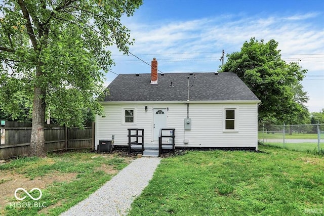 701 E Memorial Dr, Muncie, IN 47302 - rear view of house with central AC, a shingled roof, and a chimney