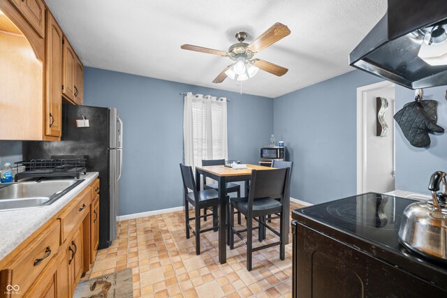 120 Hoss Rd, Indianapolis, IN 46217 - kitchen with black / electric stove, a sink, a ceiling fan, exhaust hood, and light countertops