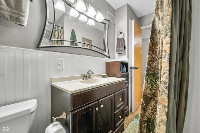 120 Hoss Rd, Indianapolis, IN 46217 - bathroom featuring vanity, toilet, and a wainscoted wall