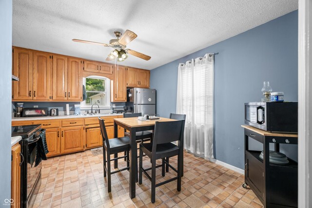 120 Hoss Rd, Indianapolis, IN 46217 - kitchen with freestanding refrigerator, black range with electric stovetop, light countertops, a ceiling fan, and a textured ceiling