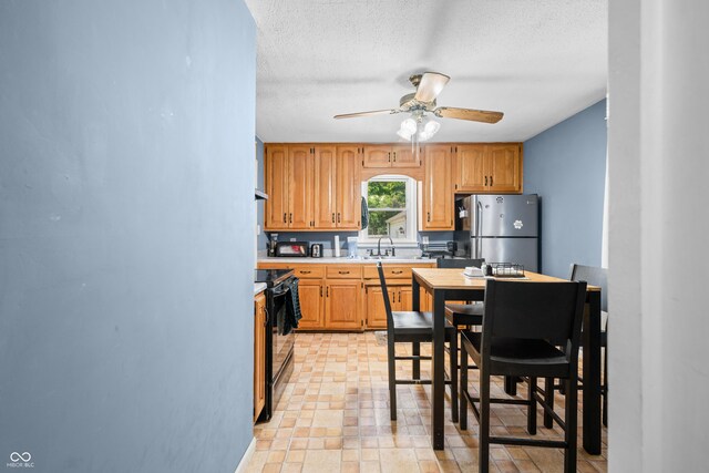 120 Hoss Rd, Indianapolis, IN 46217 - kitchen featuring freestanding refrigerator, black range with electric stovetop, ceiling fan, light countertops, and a sink