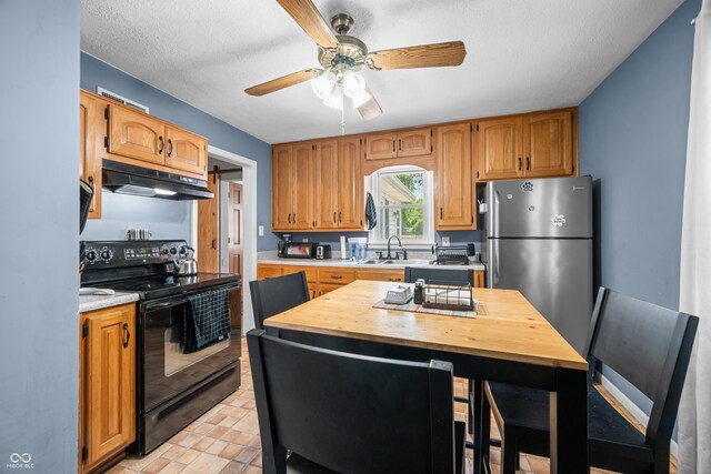 120 Hoss Rd, Indianapolis, IN 46217 - kitchen featuring electric range, under cabinet range hood, freestanding refrigerator, light countertops, and a ceiling fan