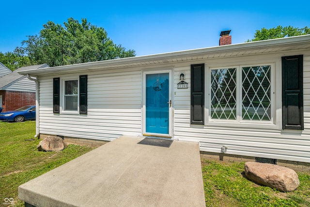 120 Hoss Rd, Indianapolis, IN 46217 - view of exterior entry featuring a chimney, crawl space, and a yard