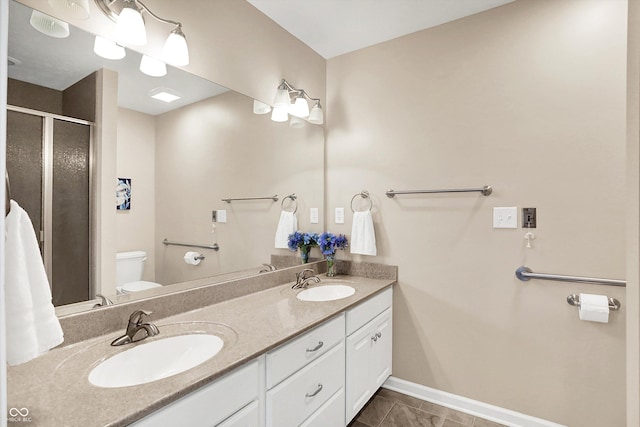 1056 Hilltop Commons Blvd, Whiteland, IN 46184 - bathroom featuring toilet, double vanity, an enclosed shower, and baseboards