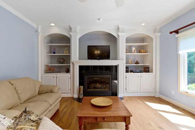 4763 Woods Edge Dr, Zionsville, IN 46077 - living room with light wood-style floors, built in shelves, a tiled fireplace, crown molding, and recessed lighting