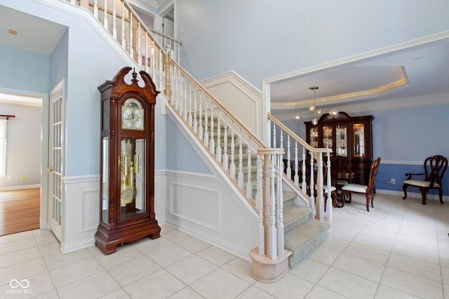 4763 Woods Edge Dr, Zionsville, IN 46077 - stairs featuring tile patterned floors, wainscoting, and a chandelier