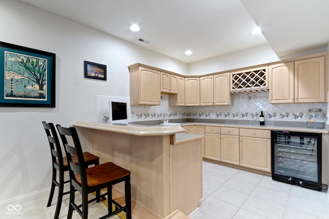 4763 Woods Edge Dr, Zionsville, IN 46077 - kitchen featuring light brown cabinets, beverage cooler, a breakfast bar area, decorative backsplash, and recessed lighting